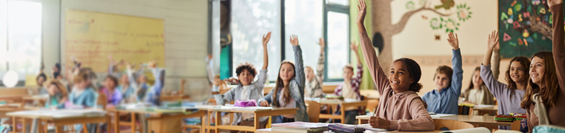 Children raising hand in classroom