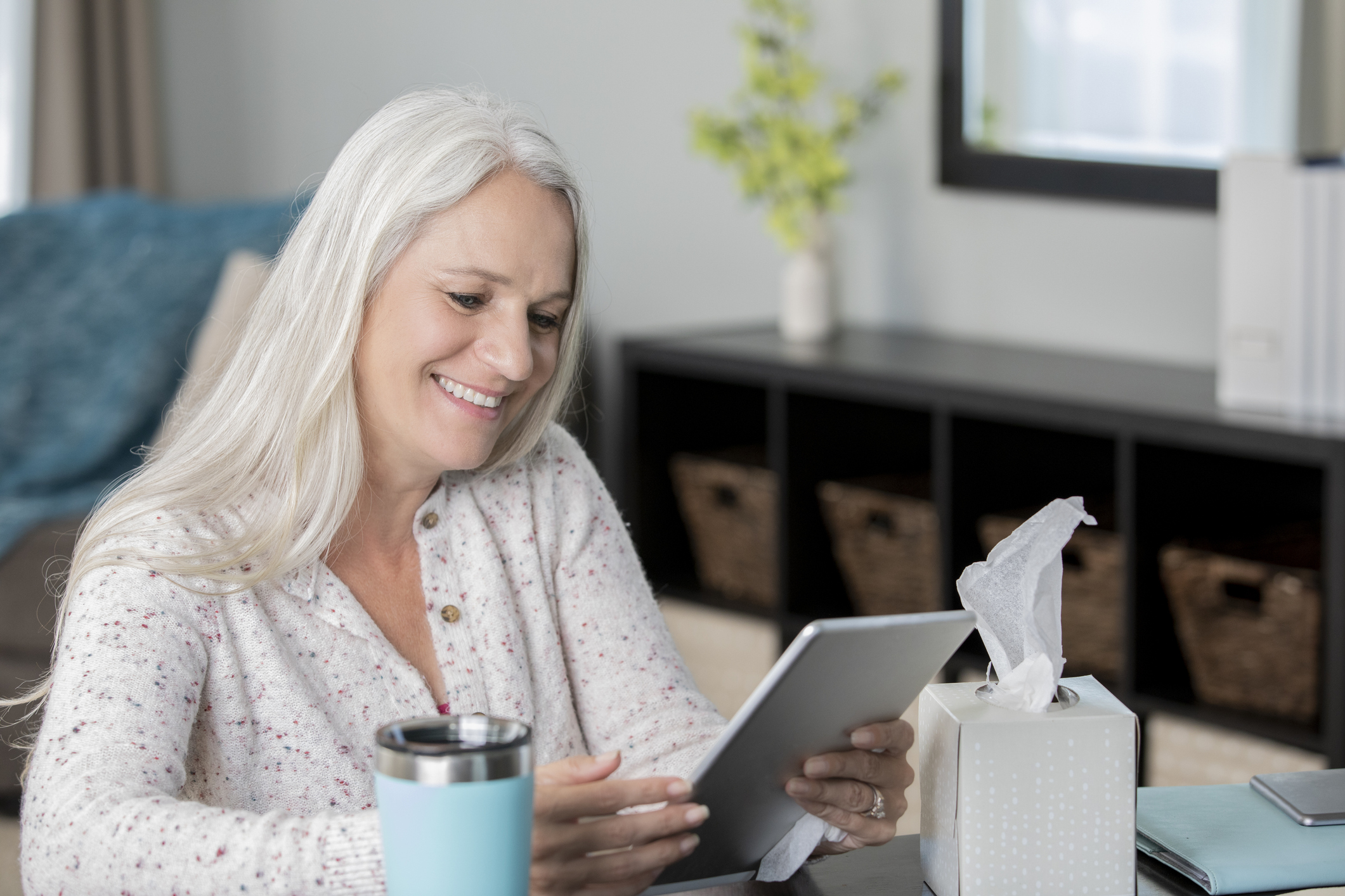 Senior woman using digital tablet has doctors appointment from living room