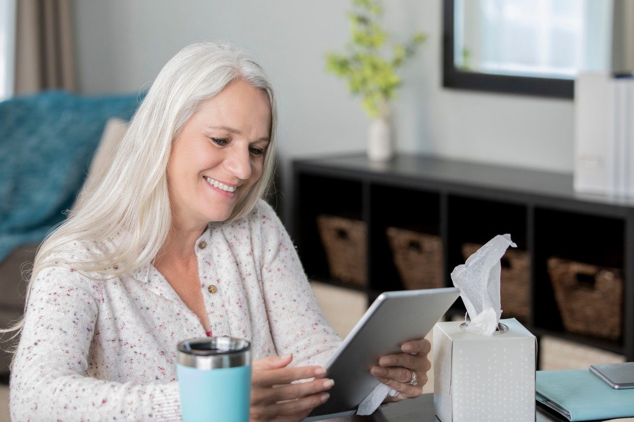 Senior woman using digital tablet has doctors appointment from living room