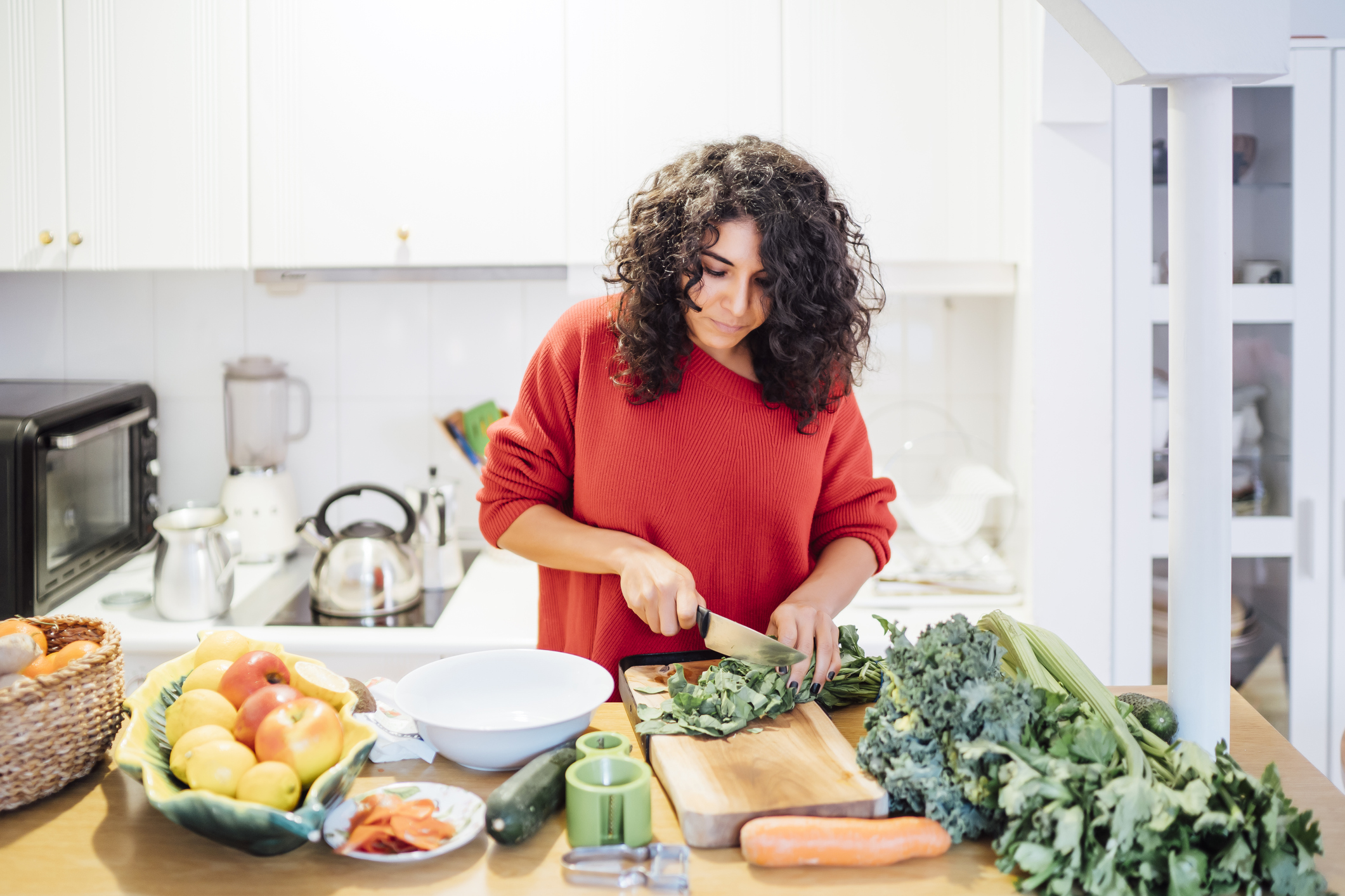 Brunette woman making a healthy green salad.