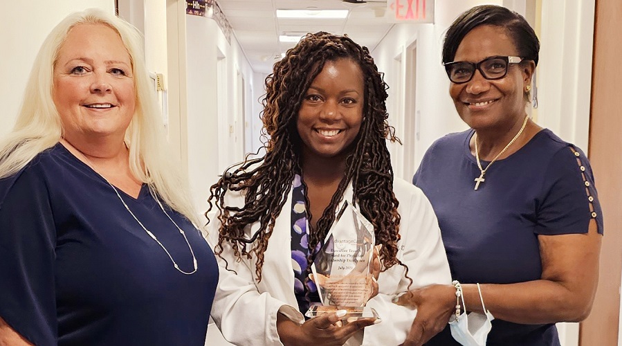 female ACPNY Valley Stream office providers smiling at camera and holding award