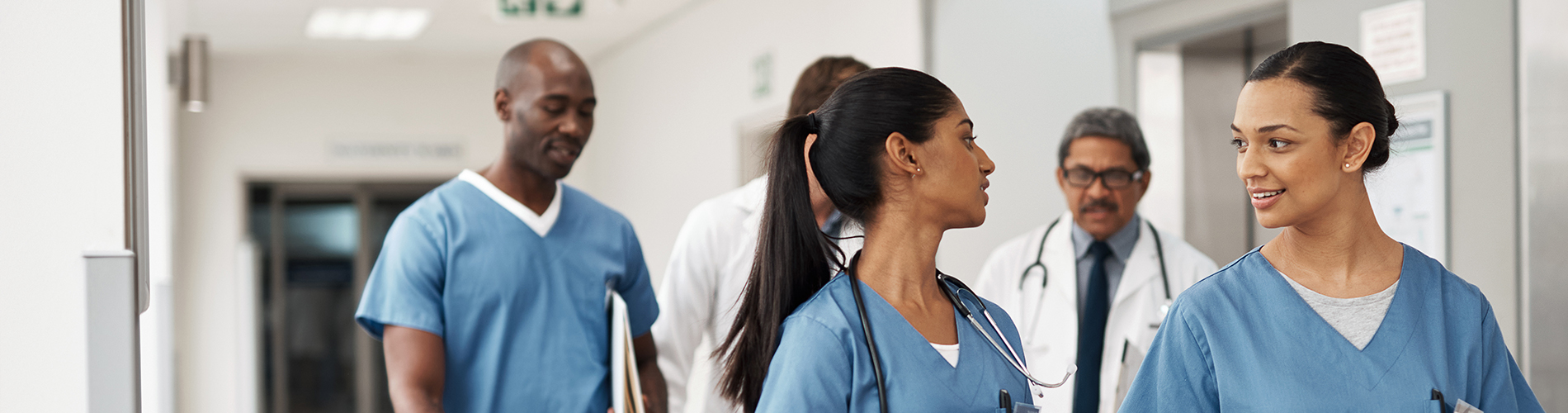 group of health care providers walking and talking in hospital