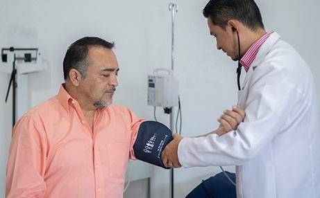 Male doctor with male patient taking blood pressure at cardiologist's office 