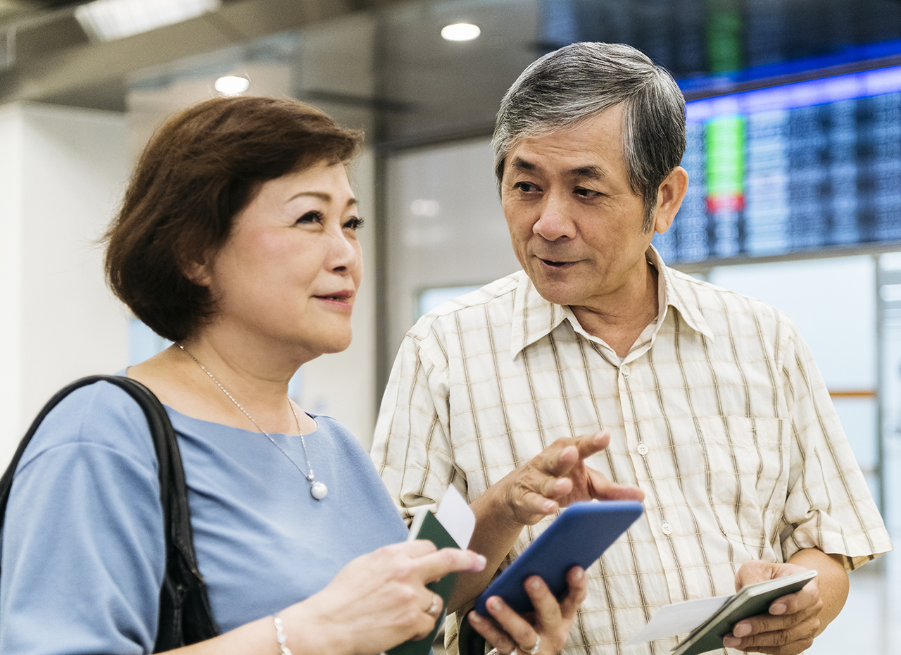 Active seniors at airport using mobile app to manage diabetes while traveling