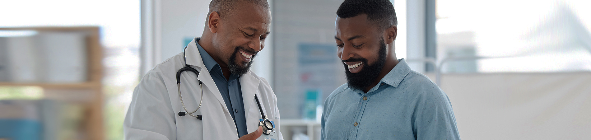 Young happy male patient with his primary care male doctor. 