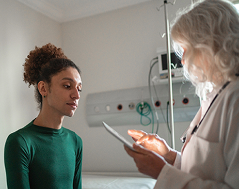 Doctor talking to patient at hospital room with digital tablet