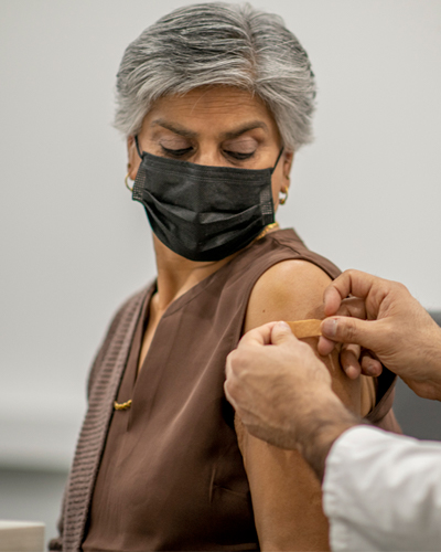 woman getting bandaid on arm