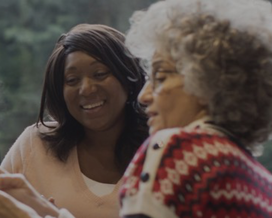 Two mature women consult device for raising awareness of immunizations