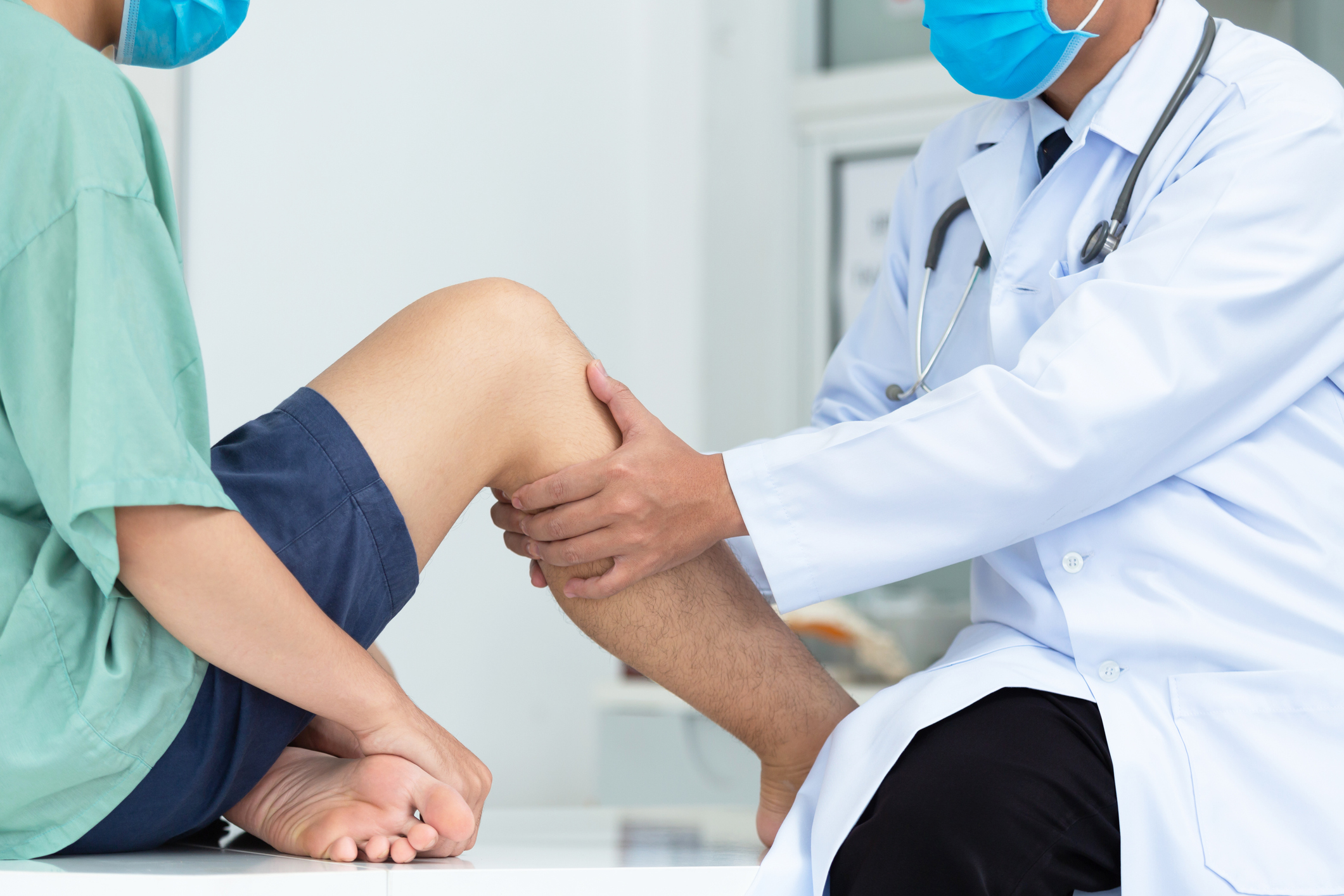 close-up hand doctor examining head of patient with knee problems in clinic.