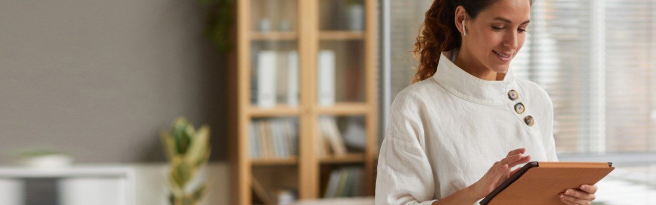 Woman looking at tablet -virtual visit faq header