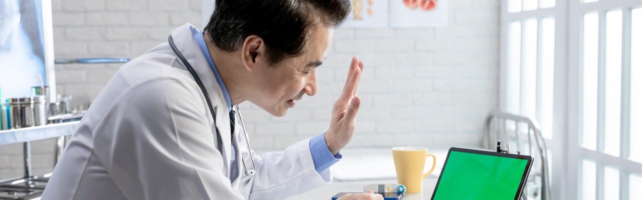 Doctor looking at laptop -virtual visits header